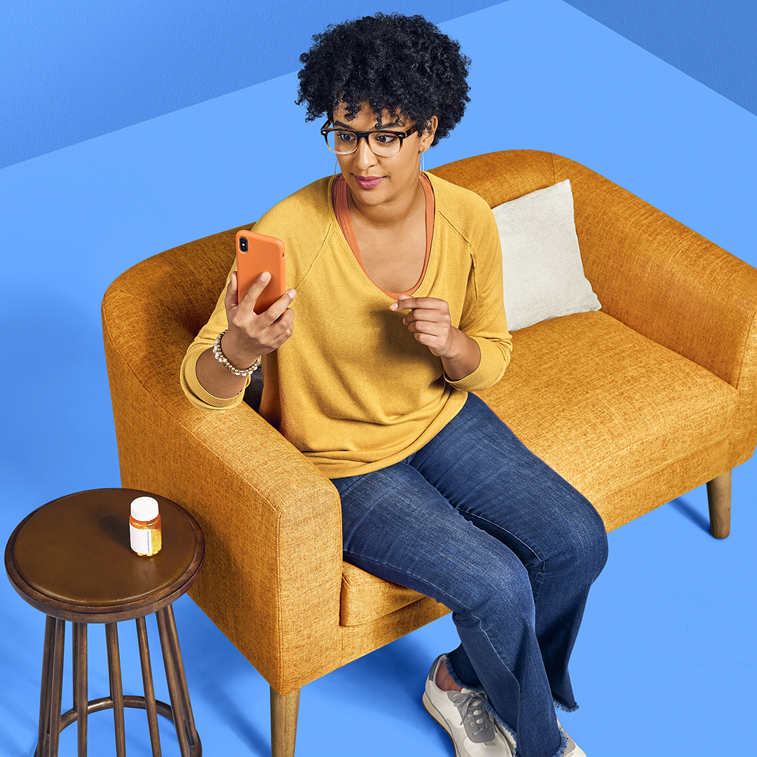 A woman checks her medications on her mobile phone using the Express Scripts® Pharmacy app.